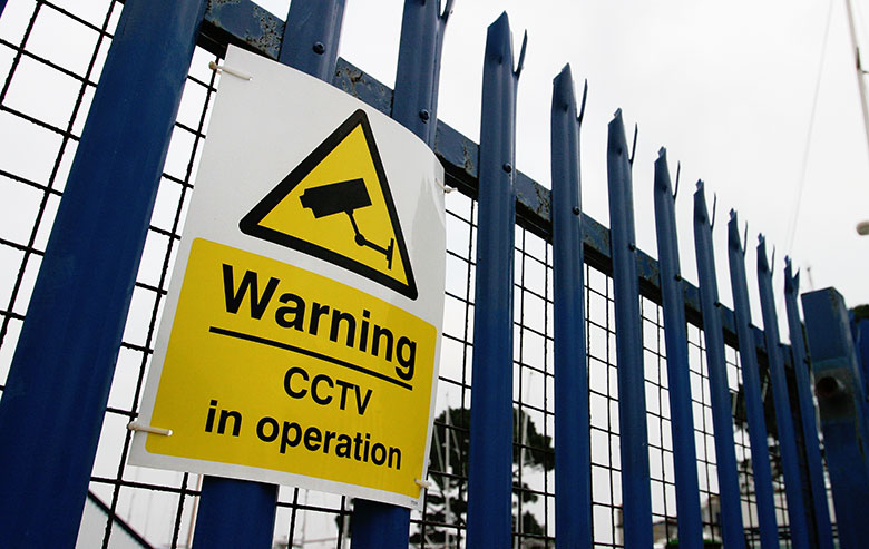 CCTV in operation warning sign on building site gates